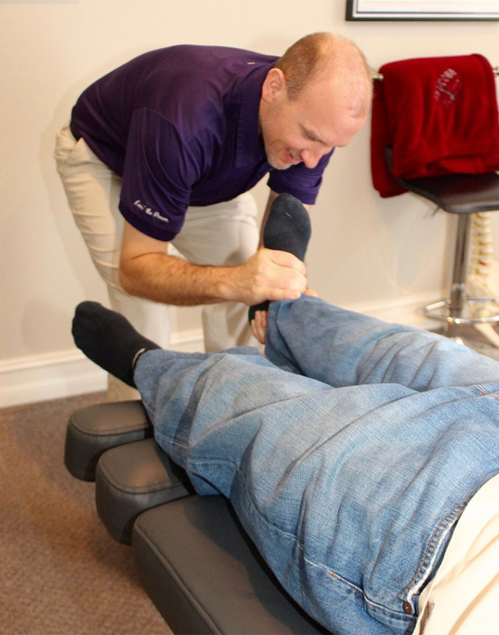 Dr Bob Bacon adjusting patients leg.