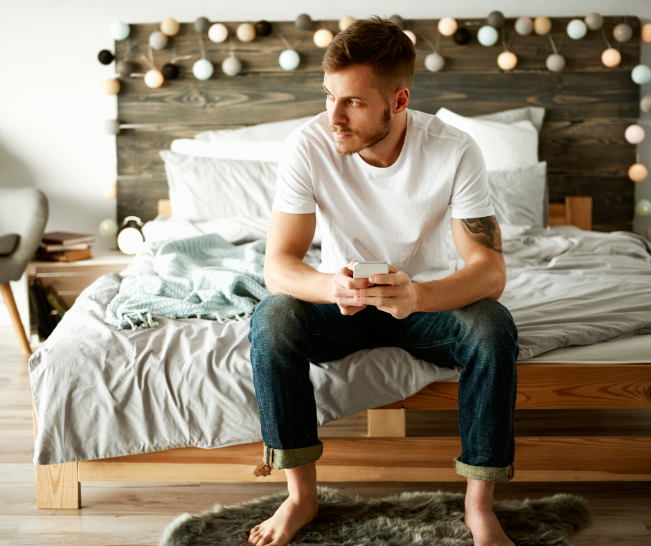 Man sitting bored on his bed, with no libido and low testosterone.